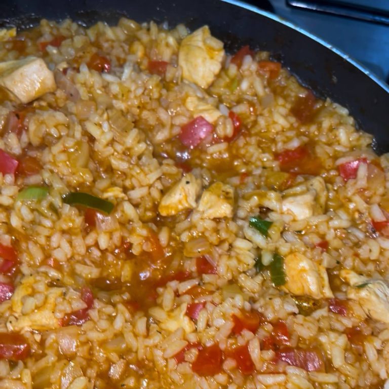 Рис із шматочками курячого філе, червоним болгарським перцем та зеленню на чавунній сковорідці