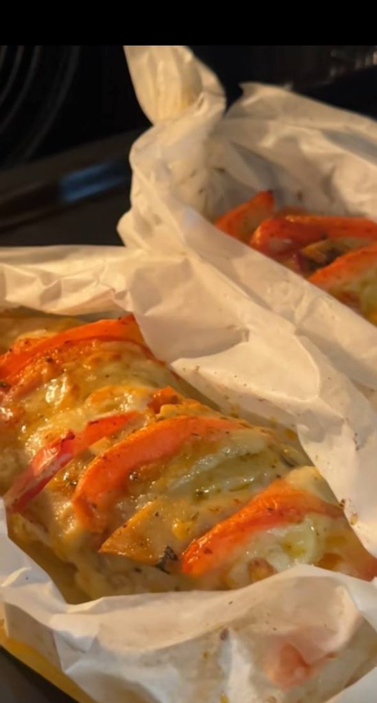 Запечене куряче філе з розрізами, наповненими скибочками червоних томатів та білою моцарелою