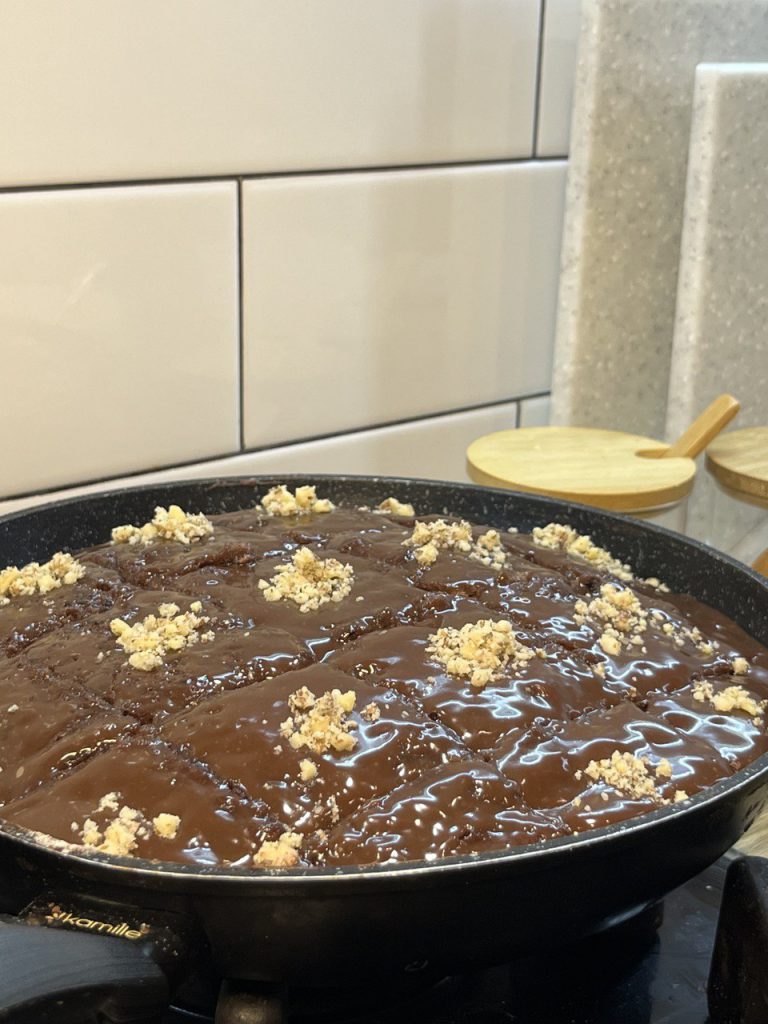 Шоколадний брауні, що готується на сковороді під кришкою.