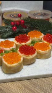 Млинці з крабовою начинкою та зеленню на білій тарілці